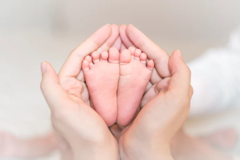 close-up-newborn-baby-feet-female-hands_33799-4092