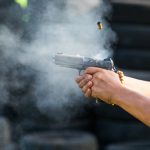 Shooting from a pistol. Reloading the gun. The man is aiming at the target